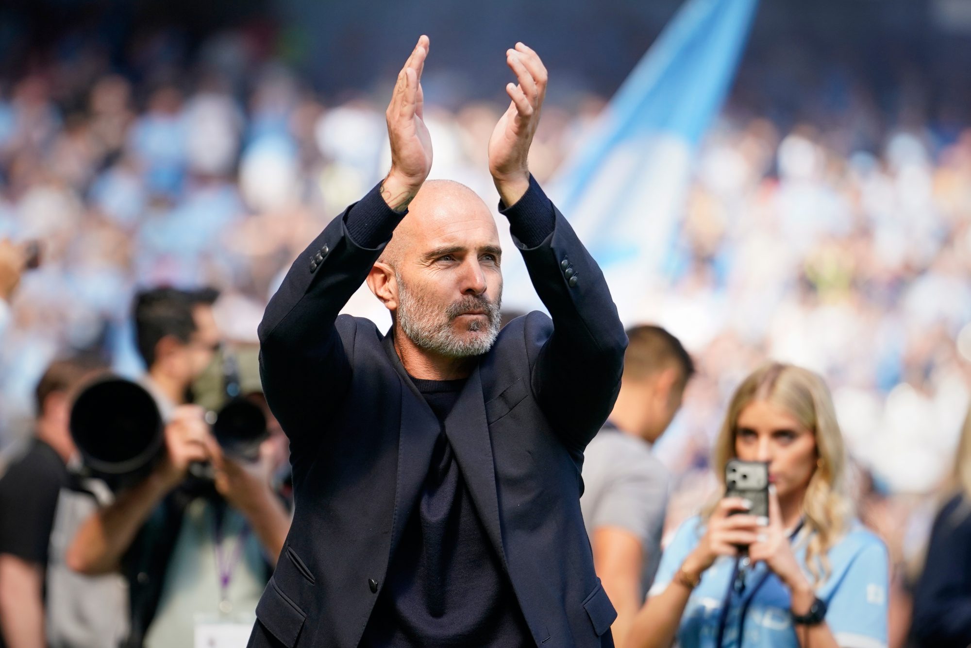 Enzo Maresca applauds Manchester City supporters from the pitch during a match at the Etihad Stadium.